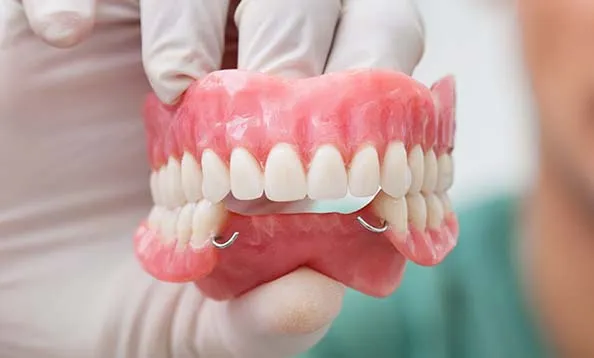 Dentist holding dentures